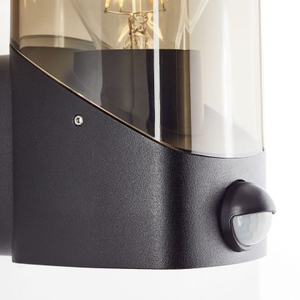 Brilliant - Aplique para exterior con sensor MINOU 1xE27/10W/230V IP44 negro/ahumado