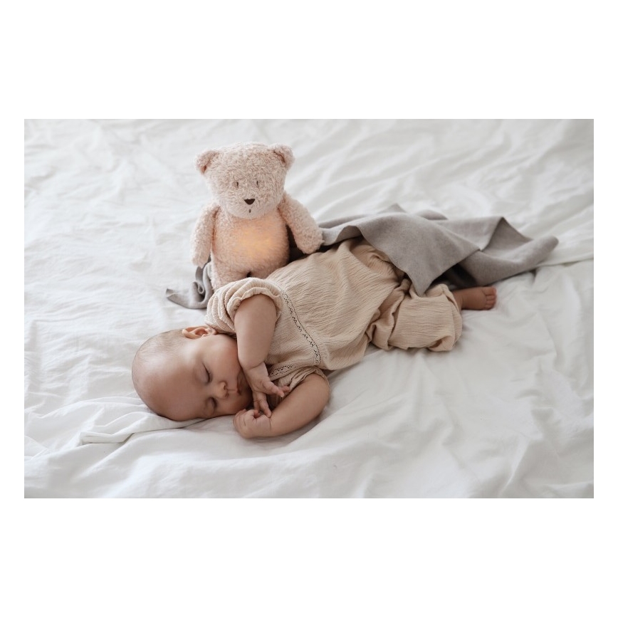 Moonie - Pelele con melodía y luz, pequeño oso de miel orgánica en tono rosado natural